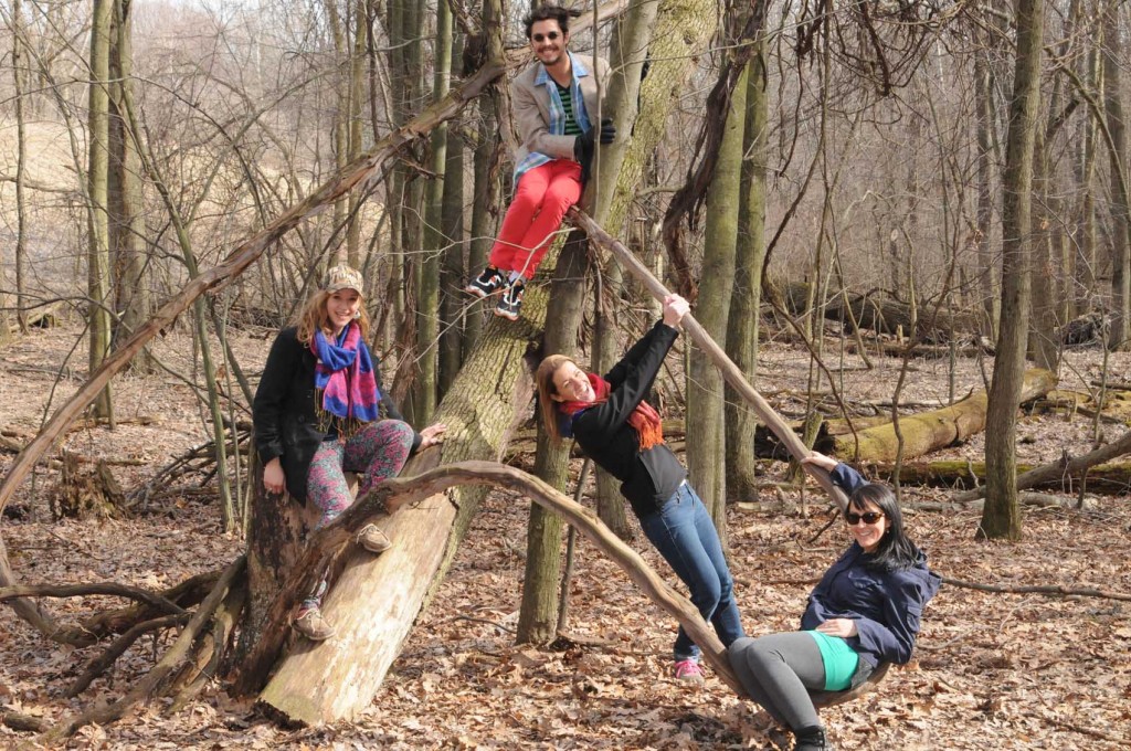 Four kids hanging out on a tree.
